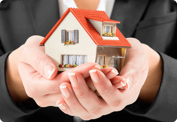 Hands holding a model house