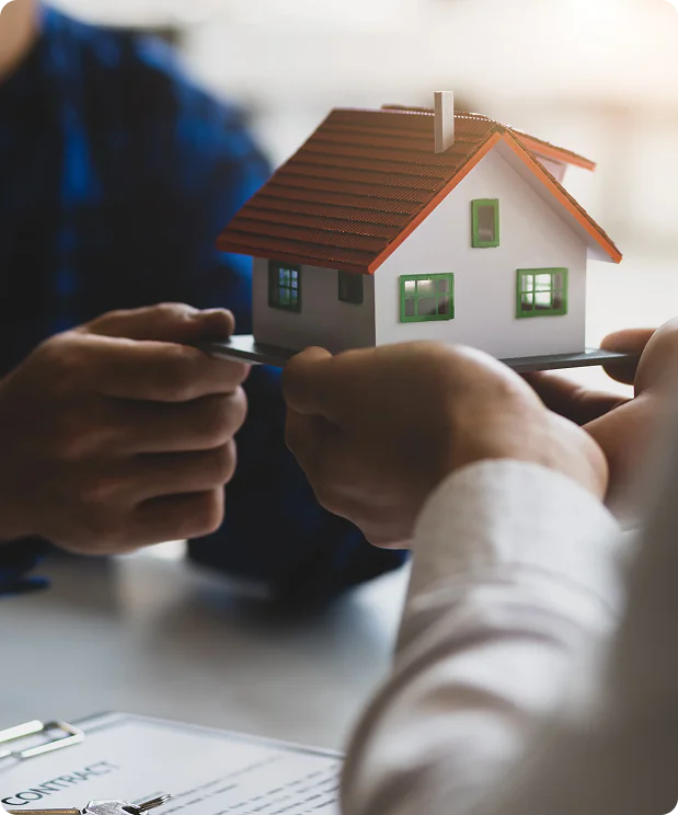 Home seller holding house keys and a model home