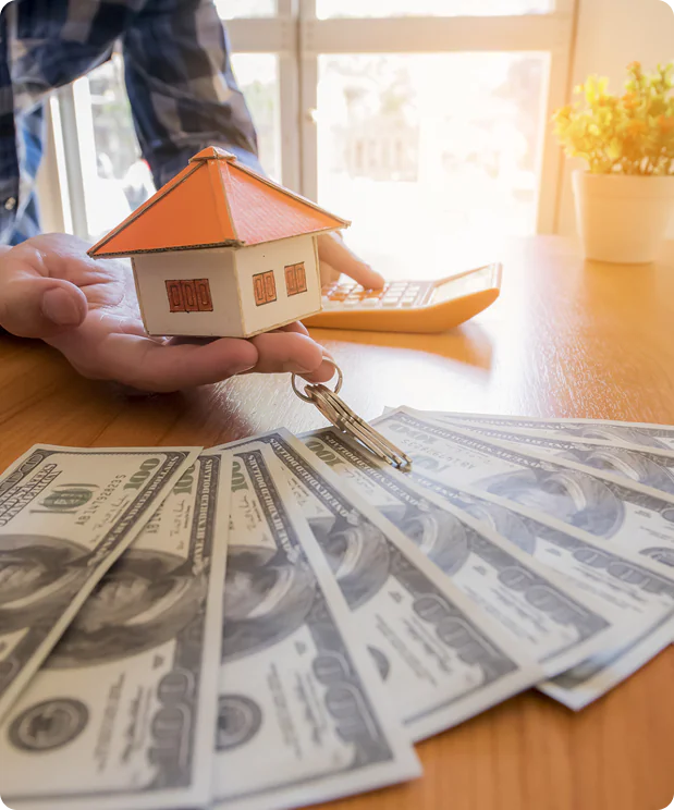 House model with cash representing a home sale